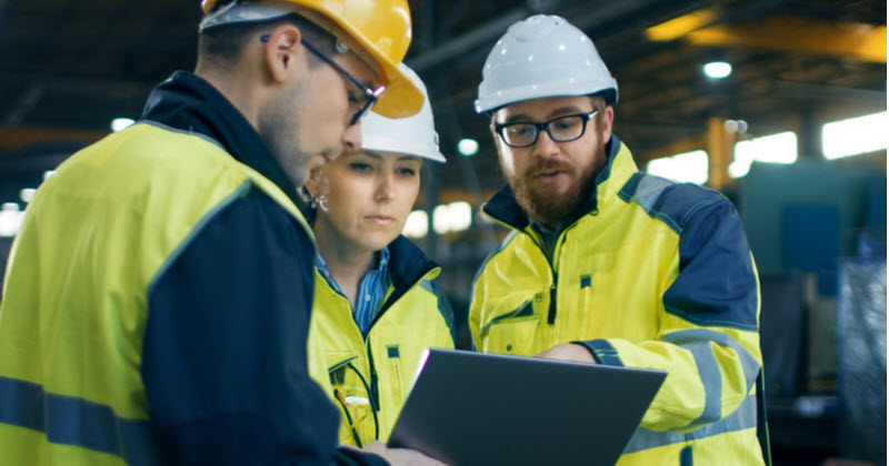 Three Industrial Engineers discussing while using laptop