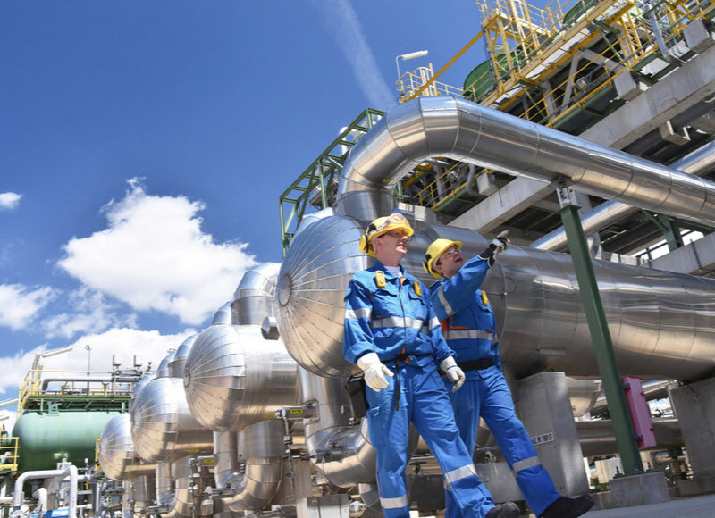 industrial workers in a refinery - oil processing equipment and machinery