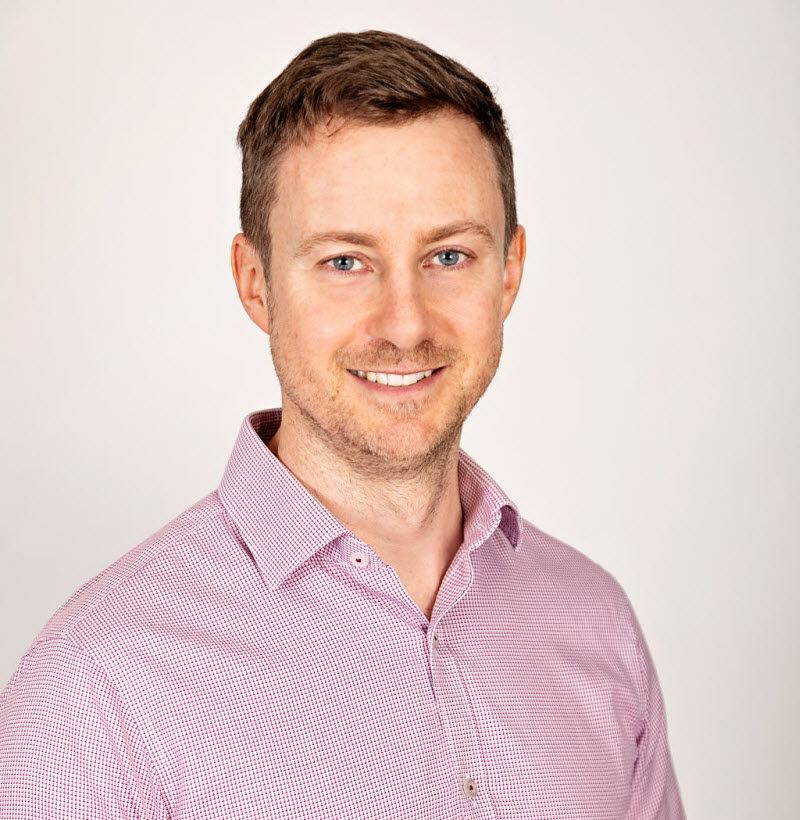 Man wearing a polo shirtsmiling at the camera