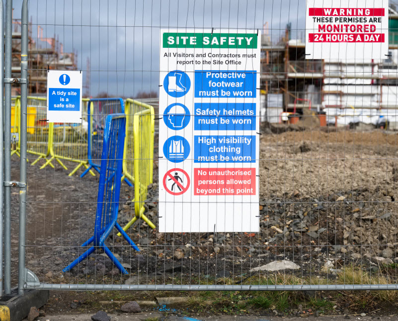 Construction site health and safety message rules sign board signage on fence boundary